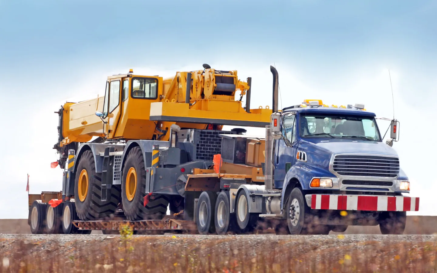Flatbed truck hauling heavy equipment