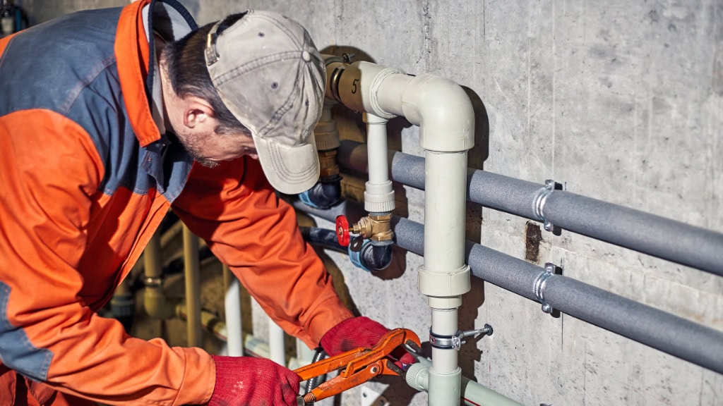Plumber installing commercial pipes
